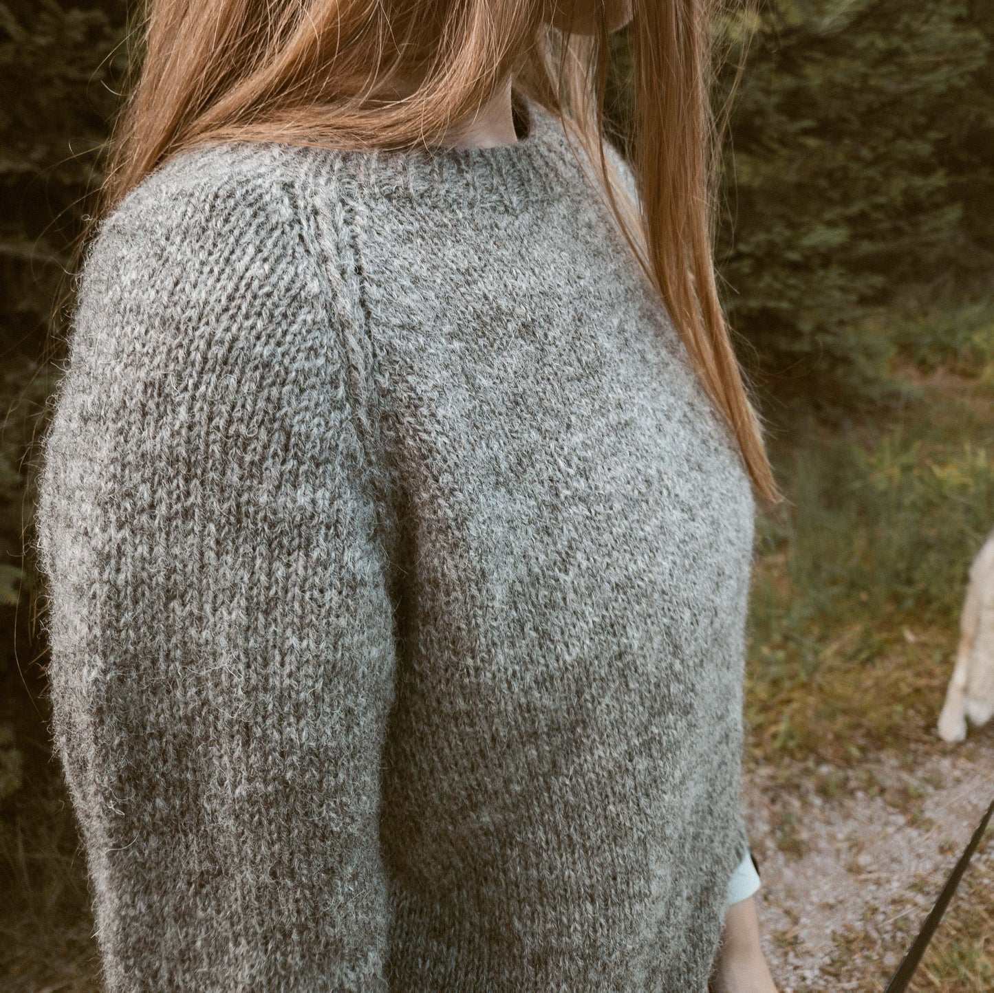 Close-up shot of the Wullpullover sweater handknit in Pommernglück from Calling Sheep, highlighting the front and shoulder detail with an intricate crochet braid.